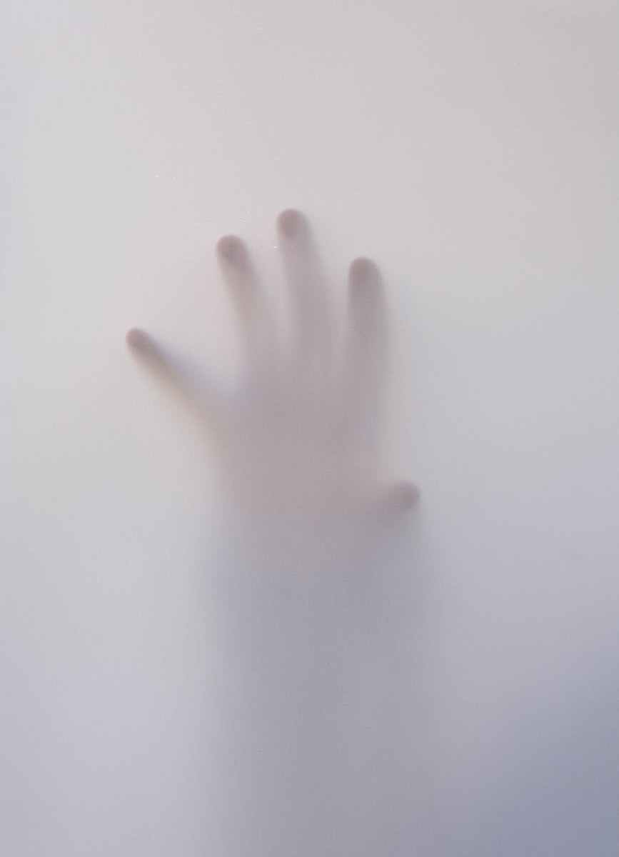 person s hand touching wall