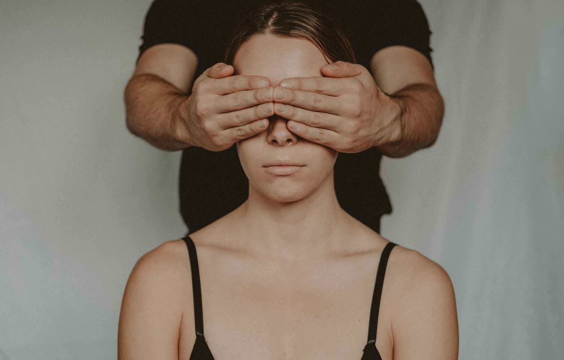crop man covering eyes of anonymous woman