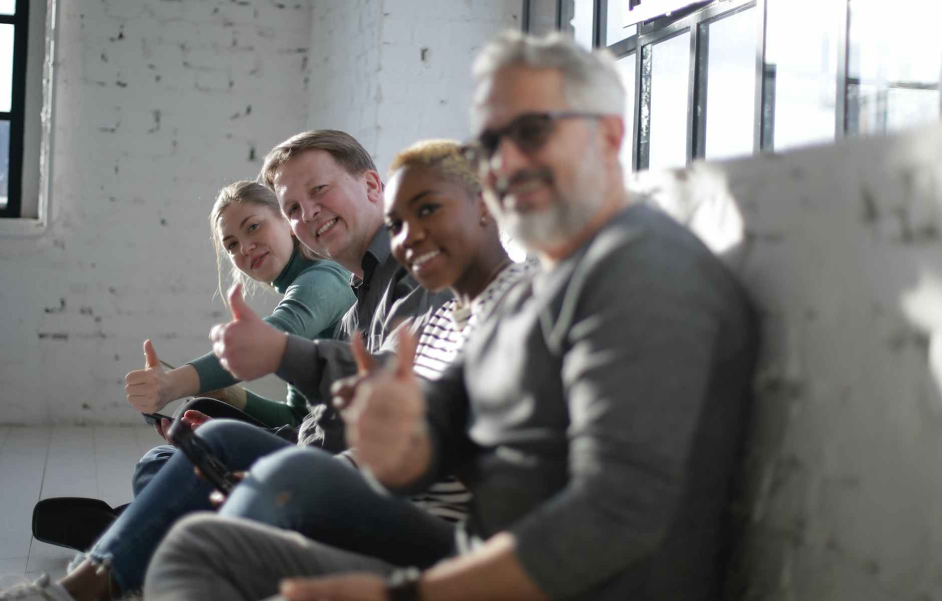 cheerful diverse friends demonstrating thumb up gesture