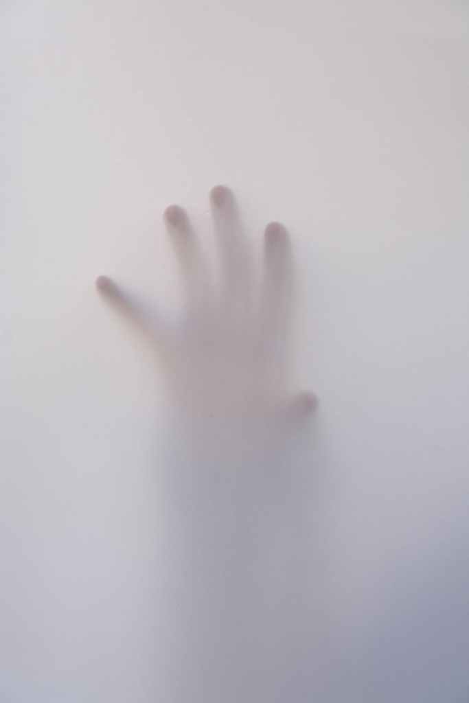 person s hand touching wall